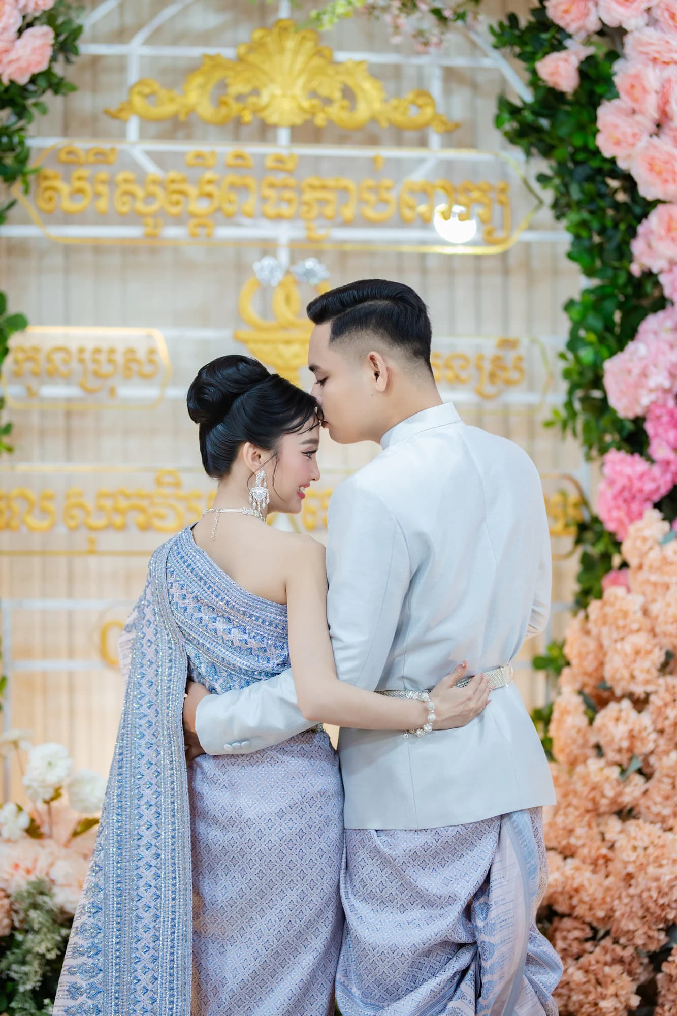 Sokvebol & Souhouy — គូស្វាមីភរិយាឱបគ្នាក្នុងឈុតមង្គលការប្រពៃណីខ្មែរ នៅមុខផ្ទាំងអក្សរមាស